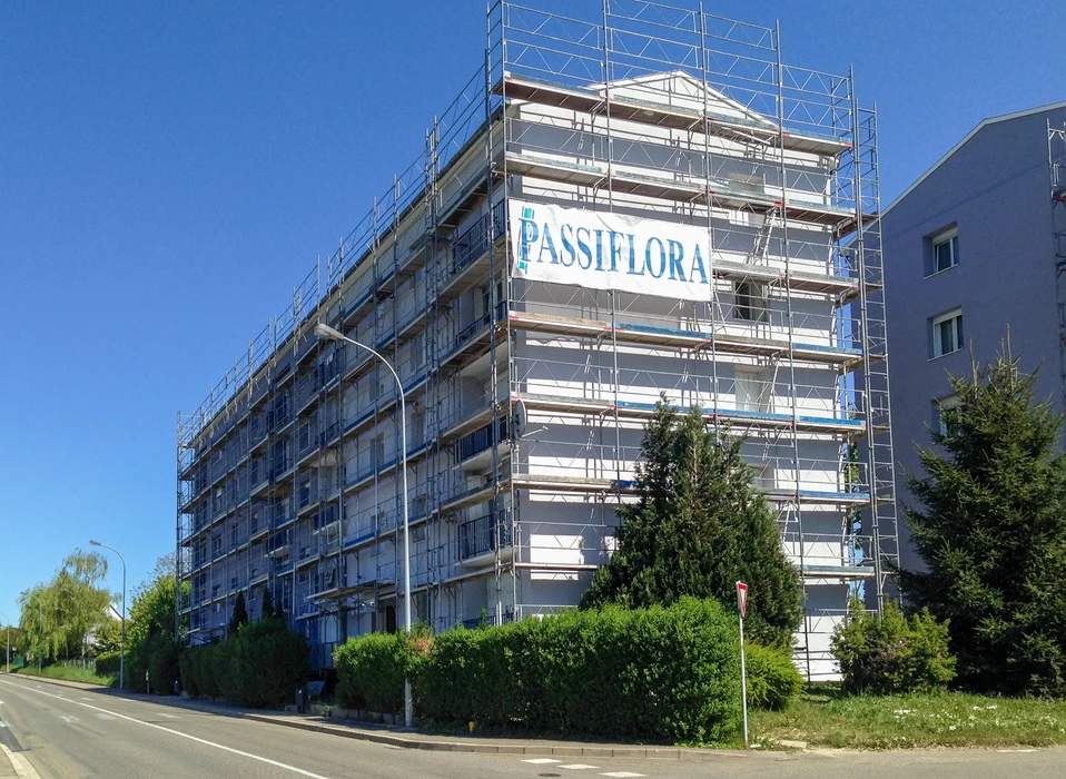 Bâtiment résidentiel de 5 étages en rénovation extérieure, entièrement recouvert d'un échafaudage tubulaire multidirectionnel