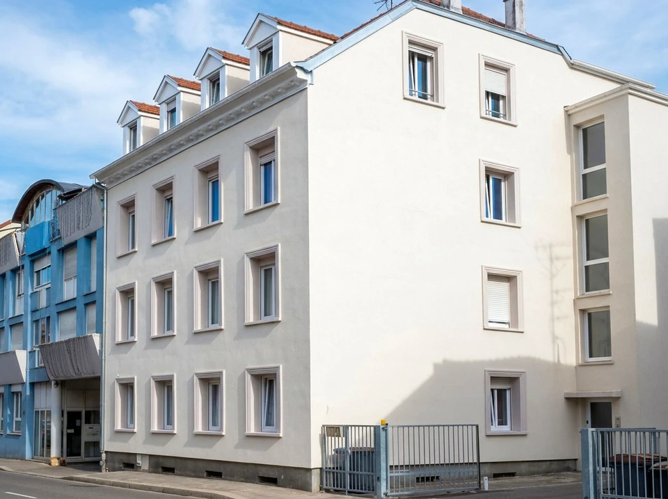 Façade d'immeuble résidentiel moderne en briques de parement beige-rosé, architecture contemporaine géométrique avec balcons filants et loggias encastrées
