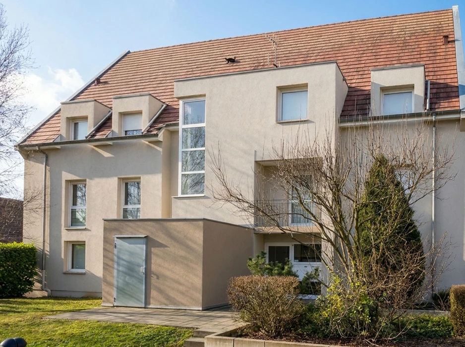 Chantier de ravalement de façade en extérieur, deux ouvriers au travail : l'un accroupi au sol, l'autre sur échafaudage tubulaire